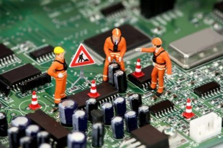 Miniature technicians working on a computer circuit board or motherboard. Tech support concept.